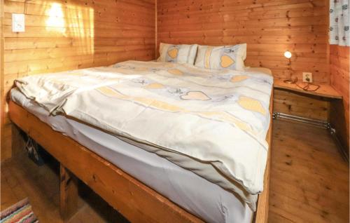 Cama grande en habitación con pared de madera en Cozy Home In Neumarkt With Kitchen, en Mühlen