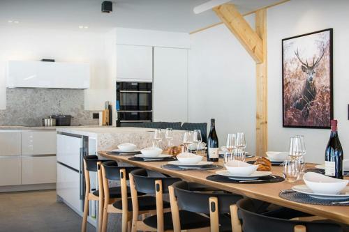 a kitchen with a long table with chairs and wine bottles at Chalet Alphonse - OVO Network in Châtel