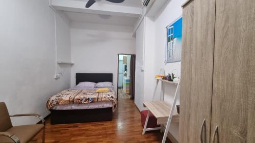ein kleines Schlafzimmer mit einem Bett und einem Stuhl in der Unterkunft Spacious Studio at citycentre in Singapur