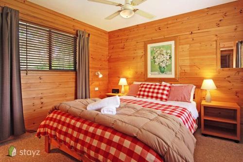 1 dormitorio con 2 camas y ventilador de techo en Blue Gums Cottage, en Valle Kangaroo