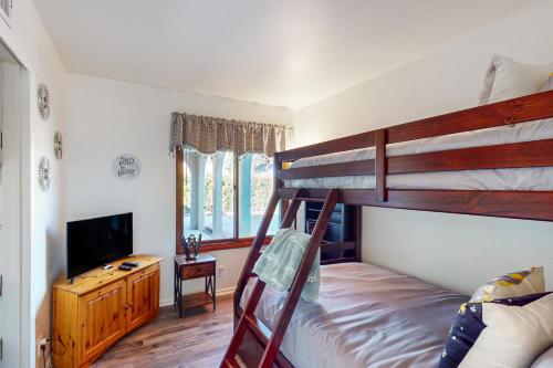 a bedroom with two bunk beds and a television at Bentons Oasis in Ventura