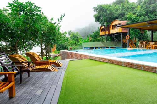 a swimming pool with chairs and a lawn next to it at Sierra Minca SEDE II in Arimaca