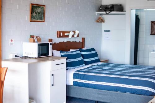 a bedroom with a bed and a computer on a desk at Avon River Inn in Stratford