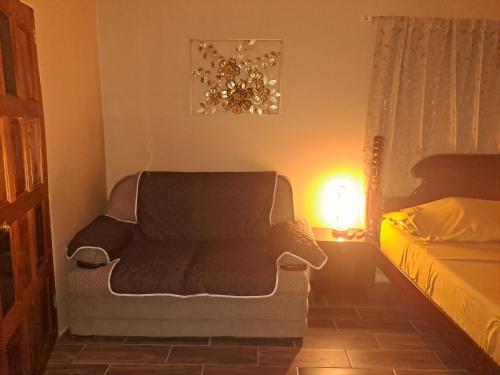 salon z krzesłem i łóżkiem w obiekcie Banyan Rose Room 3 w mieście Orange Walk