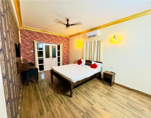 a bedroom with a bed and a brick wall at Hotel Romeo's Place Near Baga Beach - 50 meters from Baga Beach in Baga