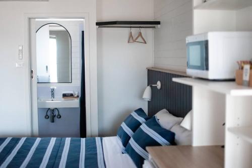 Habitación pequeña con cama y lavamanos en Avon River Inn, en Stratford