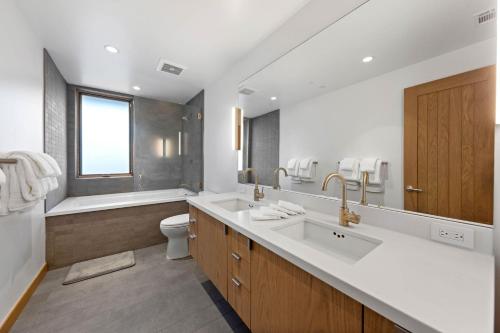 a bathroom with two sinks and a toilet and a tub at Stellar Ski In Ski Out # 2 Northstar Townhome, HOA Amenities in Truckee