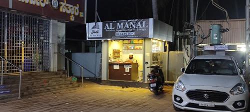 a small car parked in front of a store at AL-MANAL 306 Premium Room Triple Bed in Bhatkal