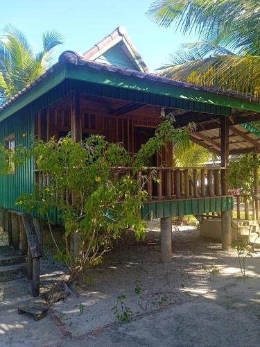 a house with a green roof on the beach at Prek Svay Bungalow in Sihanoukville