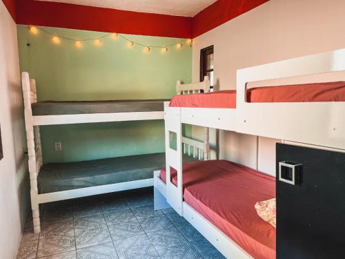 a room with two bunk beds and lights at Casa 2 - Estrela Dalva in Farol de Santa Marta