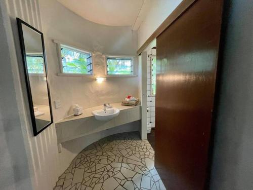 a bathroom with a sink and a mirror at Tapunui Spacious Retreat with Superfast Internet in Arorangi
