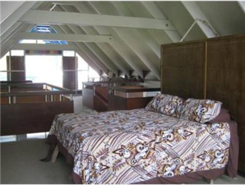 a bedroom with a bed in a attic at Tapunui Spacious Retreat with Superfast Internet in Arorangi