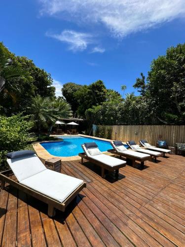 a row of lounge chairs next to a swimming pool at Pousada Santo Mar in Arraial d'Ajuda