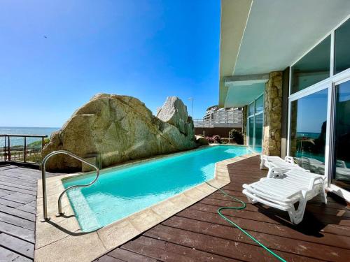 una casa con piscina accanto a un edificio di Hermoso Depto, 1Linea Roca Mar Sector Costa Brava a Concón
