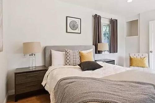 um quarto com uma cama, 2 candeeiros e um espelho em Spacious 3Bdr Home close to Manhattan Beach em Lawndale