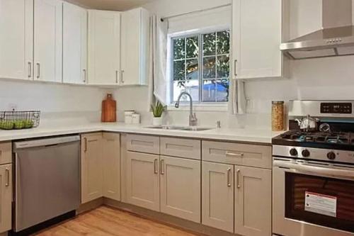 uma cozinha com armários brancos e um lavatório em Spacious 3Bdr Home close to Manhattan Beach em Lawndale