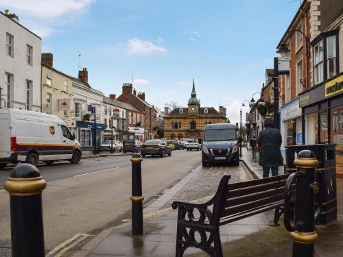 a person sitting on a bench on a city street at Racing Retreat in Towcester