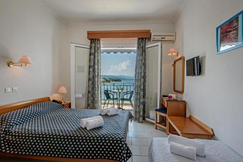 een slaapkamer met een bed en uitzicht op de oceaan bij Lazaridis Luxury Studios & Apartments in Nea Roda