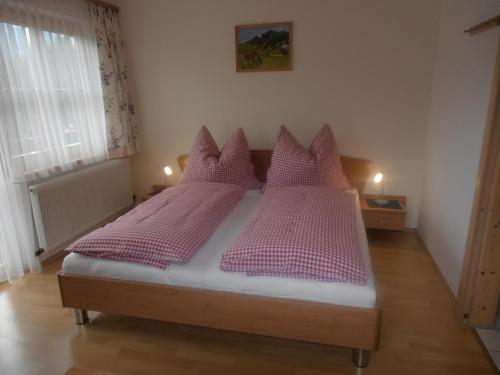 a bedroom with a bed with purple pillows at Bauernhof Bachgut in Mühlbach am Hochkönig