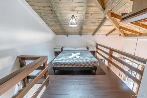 een slaapkamer met een bed in een kamer met houten plafonds bij Pousada Refúgio do Rosa in Praia do Rosa