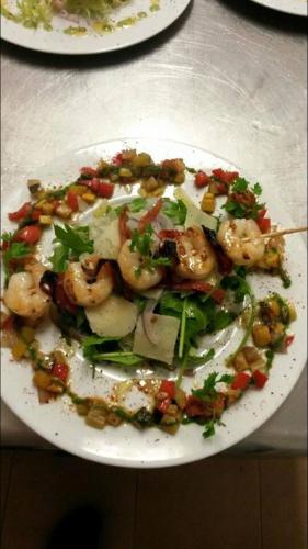 a plate of food with shrimp and vegetables on a table at Hotel La Cigale in La Croix-Valmer