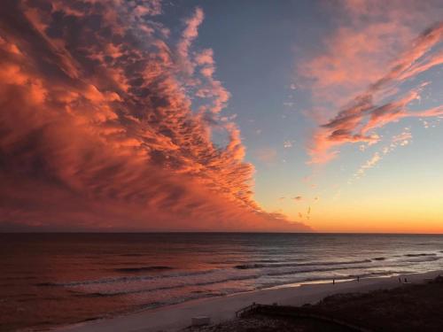 a sunset on the beach with a cloudy sky at Beachfront Bliss Absolute Gulf Front 2 Bedroom Condo in Navarre