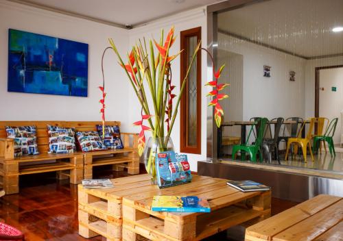 a room with two wooden tables and a table with flowers at Hotel Agatalh Pinares Alto Pereira in Pereira