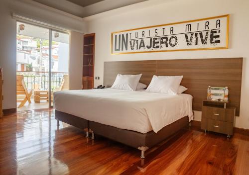 a bedroom with a large bed with a wooden headboard at Hotel Agatalh Pinares Alto Pereira in Pereira