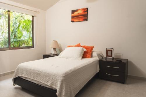 a white bedroom with a bed and a window at Casa Serena in Cancún