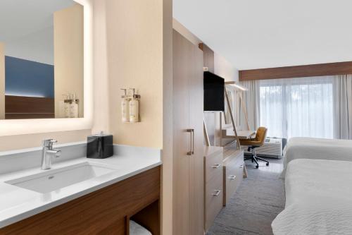 a bathroom with a sink and a bed in a room at Holiday Inn Express Hilton Head Island by IHG in Hilton Head Island