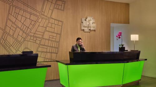 a man sitting at a desk with a microphone at Holiday Inn Singapore Atrium by IHG in Singapore