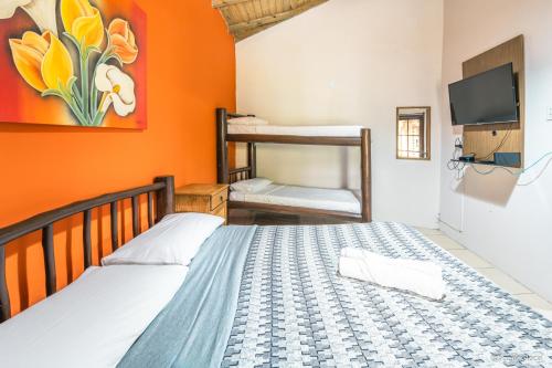 een slaapkamer met 2 bedden en een stapelbed bij Pousada Refúgio do Rosa in Praia do Rosa
