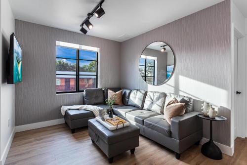 a living room with a couch and a mirror at Lux Retreat By Renzzi in Miami