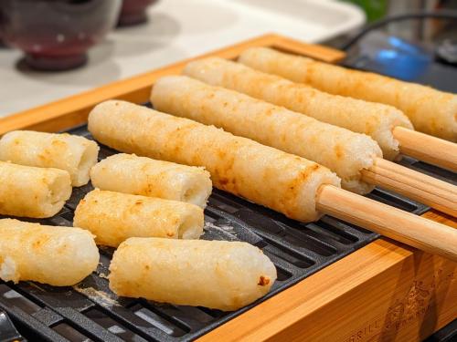 a group of sticks cooking on a grill at APA Hotel Akita Senshu Koen in Akita