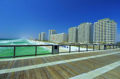 a boardwalk next to the beach with tall buildings at Beachfront Bliss Absolute Gulf Front 2 Bedroom Condo in Navarre