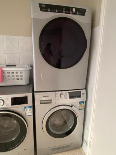 a washing machine and a dryer in a kitchen at Sunny Ocean View Retreat in Perth