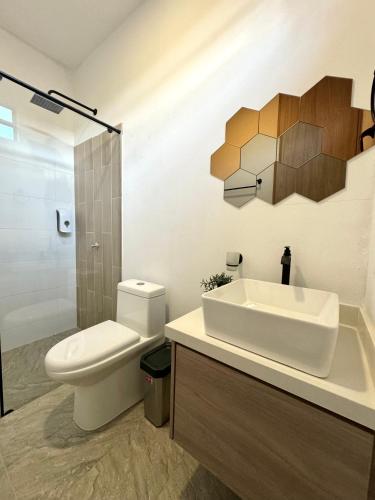 a bathroom with a white toilet and a sink at CASA PALMANOVA CON PISCINA EN LA MESA in La Mesa