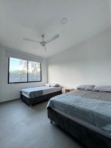 um quarto com 2 camas e uma ventoinha de tecto em CASA PALMANOVA CON PISCINA EN LA MESA em La Mesa