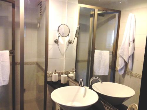 a bathroom with two sinks and a shower with a mirror at Apartment Bello Horizonte in Santa Marta