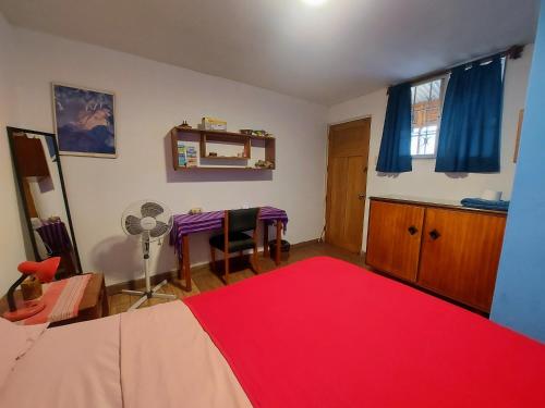 1 dormitorio con cama roja y mesa con alfombra roja en Habitación con baño privado acceso a cocina y terraza en Miraflores, en Lima