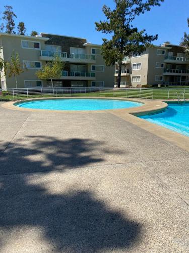 una gran piscina frente a un edificio en Departamento en Algarrobo, en Algarrobo