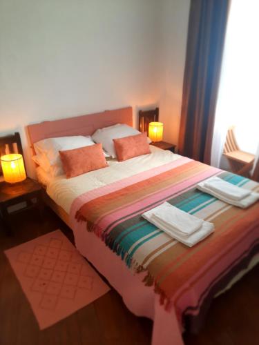 a bedroom with a large bed with towels on it at Casa Malva - Traditional townhouse apartment in Monchique