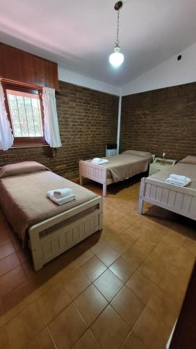 Cette grande chambre comprend deux lits et deux tables. dans l'établissement Casa Rumipal, à Villa Rumipal