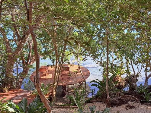 a wooden deck with trees and water in the background at 7 CIELOS BACALAR. in Bacalar