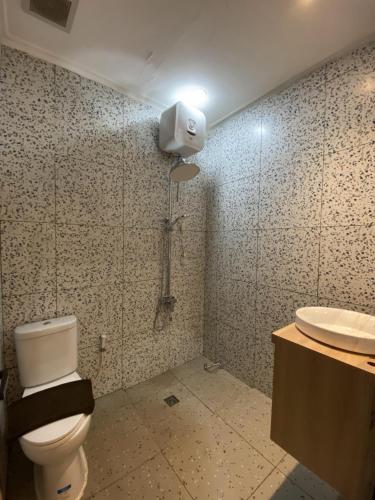 a bathroom with a toilet and a sink at La Berza Resort in Subang