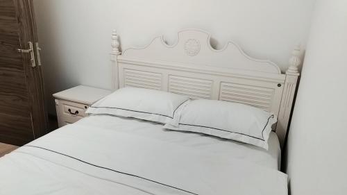 a white bed with white sheets and pillows at 森林城市安排05 in Kampong Pok Kechil