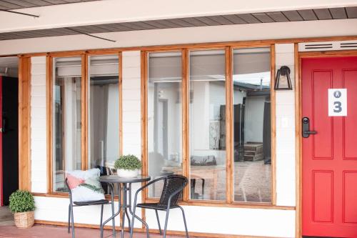 a patio with a red door and chairs at Avon River Inn in Stratford