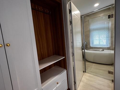 a bathroom with a shower and a bath tub at Duy Quan Villa NovaWorld Phan Thiet 04 in Bình Tú