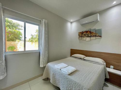 a bedroom with a bed and a window at Pousada Beach House Dunas in Beberibe
