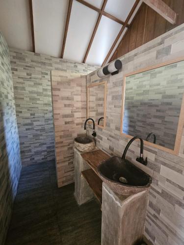 a bathroom with two sinks and a large mirror at SELAYAR TURTLE BAY in Barangbarang